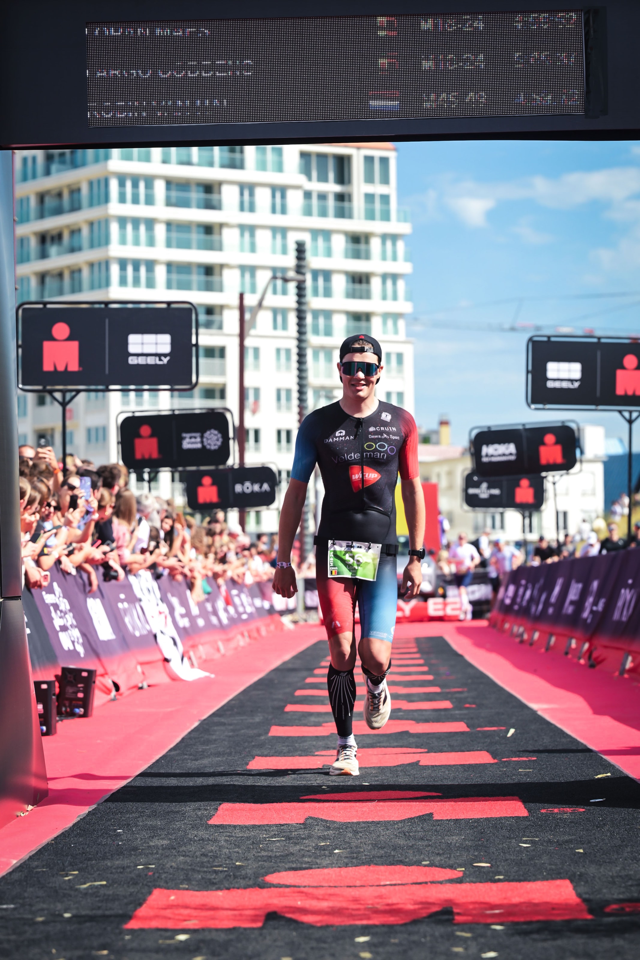 Loran Maes spreidt zijn armen op de finishmat van IRONMAN Vitoria-Gasteiz
